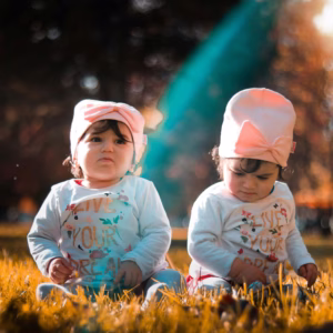Autistic Twins On Grass Field
