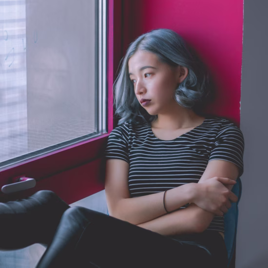 Woman in Black and White Striped Shirt While Looking Out at the Window