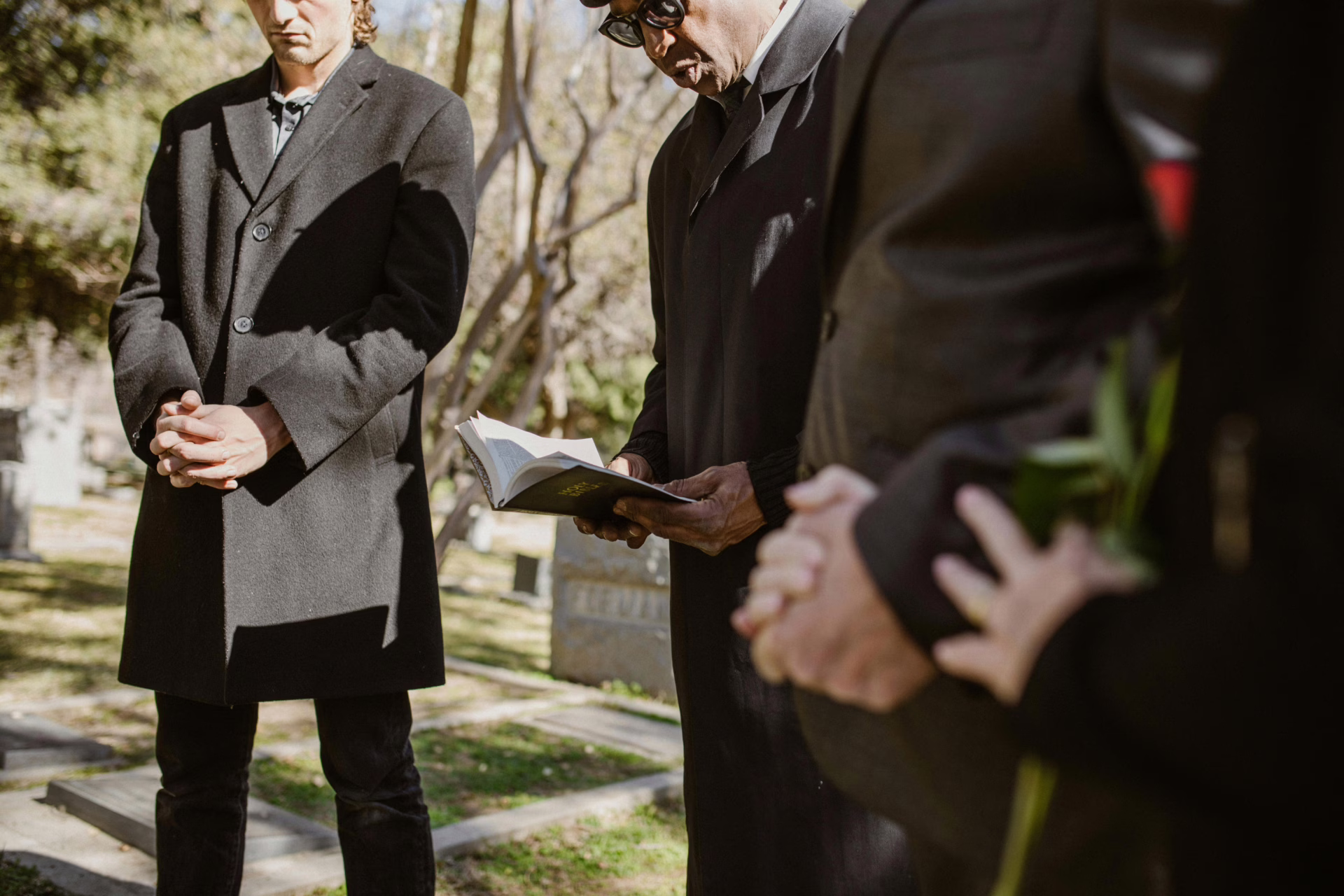 People standing at a gravesite attending a funeral.