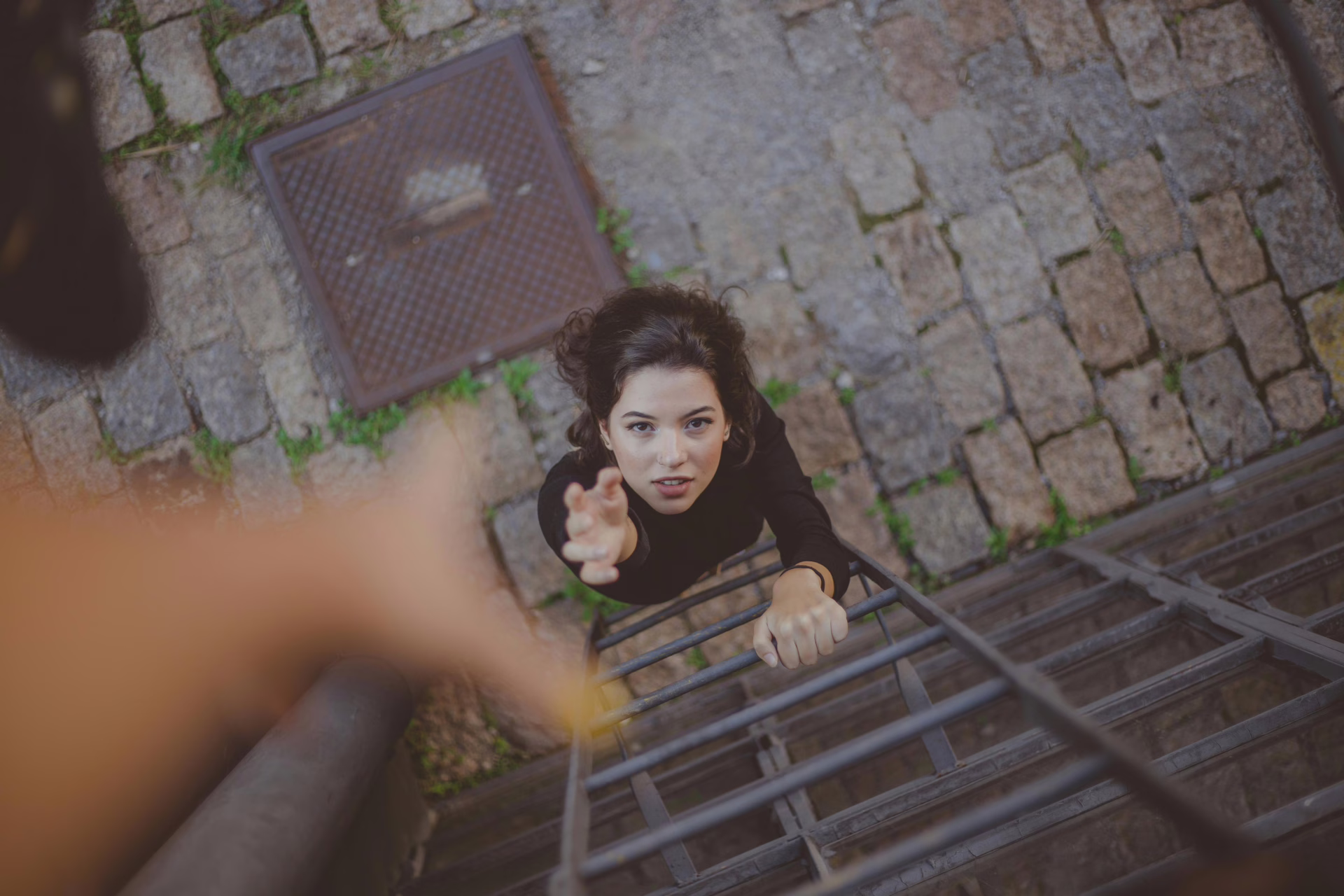 Woman reaching for help up a ladder
