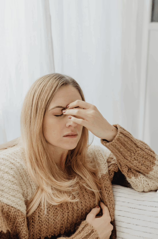 Woman with migraine holding head.