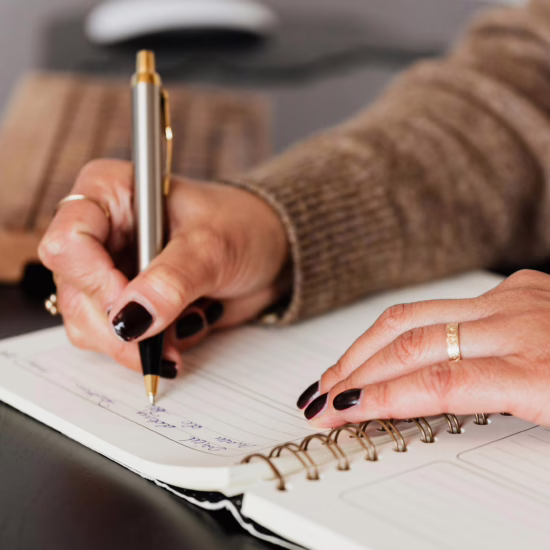 Closeup of woman writing in a journal